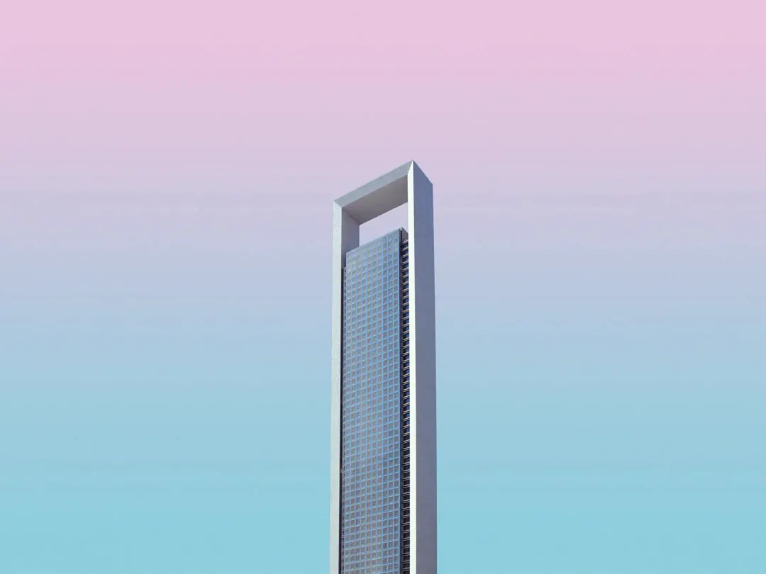 A single office tower against a pink and blue sky